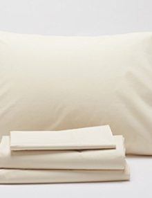 Stack of Coyuchi Sateen sheets, pillow case and pillow